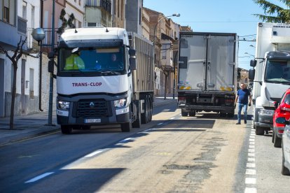 Camions passant per la carretera, que té el ferm en mal estat, aquest dimarts.