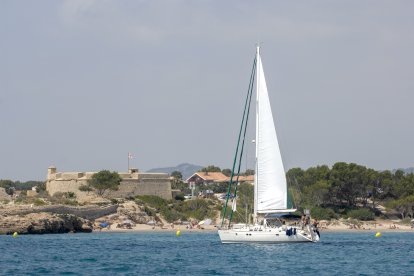 Un veler navegant per la costa de l'Ametlla de Mar.