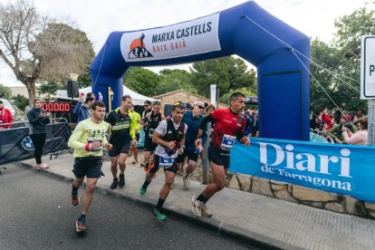 Algunos atletas pasando ante la pancarta del Diari.