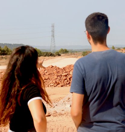 Dos dels membres de la plataforma En peu de terra als terrenys on s'està construint el Logis Montblanc