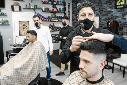 Rachid, en su peluquería de Campclar antes de realizar un corte a uno de sus clientes.