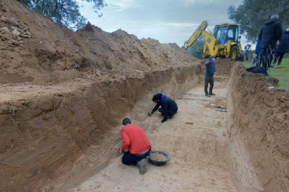 Arqueòlegs treballant ahir a la fossa al Mas de Santa Magdalena, a la serra de Cavalls.