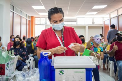 Una mujer prepara una vacuna.