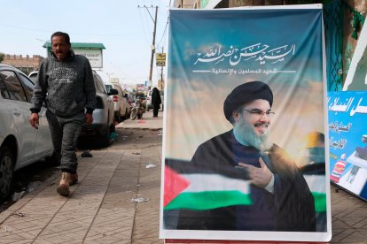 Un hombre camina junto a una imagen del fallecido líder de Hizbulá, Hasan Nasralá, en Saná (Yemen).