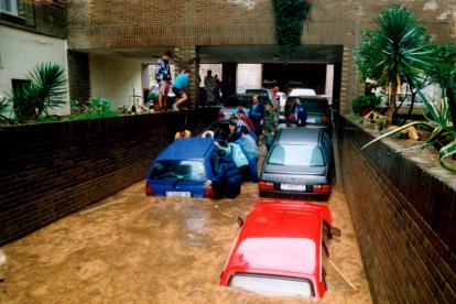 Los vecinos intentando salvar algunos de los coches que estaban en los parkings.