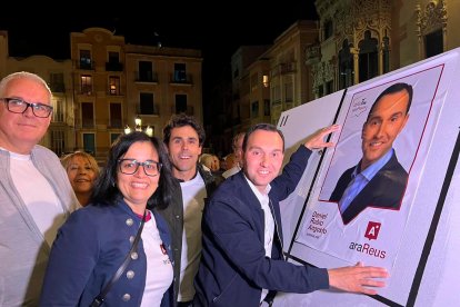 Dani Rubio (Ara Reus) y su equipo colgando el cartel en el Mercadal.