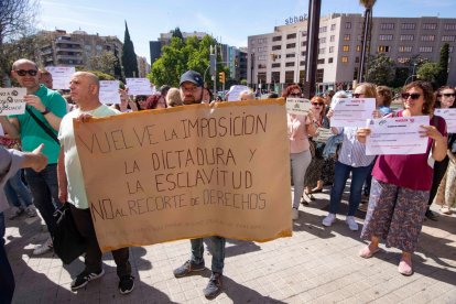 Un trabajador sostiene un cartel que critica a la Administración.