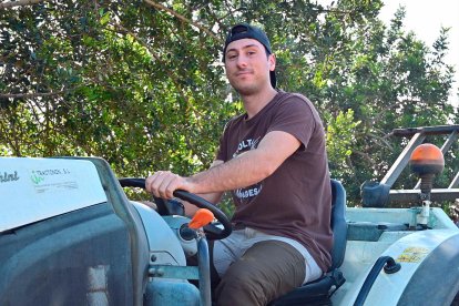 A bord del seu tractor, Arnau Salvat, que té finques d’olivers i garrofers a Maspujols, a Riudoms, a Reus i a l’Aleixar.