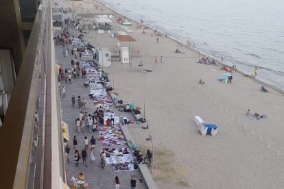 Un tramo del paseo marítimo lleno de manteros.
