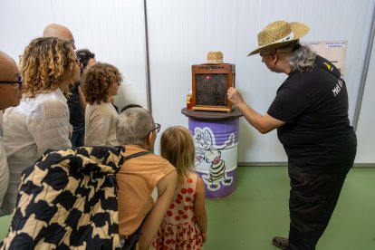 Els visitants de Mel el Remei veient l’interior d’un rusc de la mà de Joan Maria.