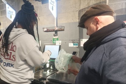 El tarraconense Santos Masegosa y Bianca, pagando en una máquina del mercado.