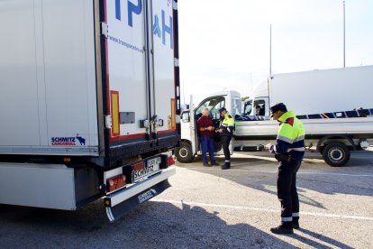 Un agente de los Mossos inspecciona un camión en un control en L'Aldea