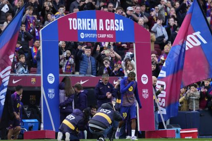 Lamine Yamal pasa junto a un cartel alusivo al regreso del equipo a su estadio antes del partido de LaLiga entre el Barcelona y el Athletic Club, este sábado en el Camp Nou.