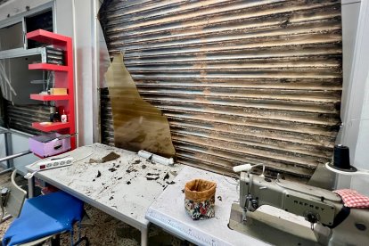 Interior del taller de costura afectado por el incendio, que ha sufrido la rotura de las ventanas.