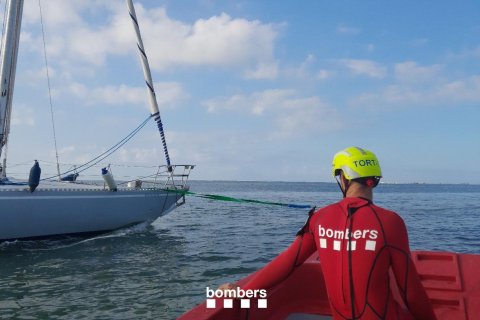 Imagen de los Bombers junto al velero que ha tenido que ser rescatado en La Ràpita