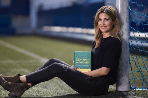 Danae Boronat posa junto con el libro en la portería del campo del Nou Sardenya del CE Europa.