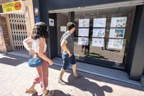 Dos jóvenes mirando pisos en una inmobiliaria