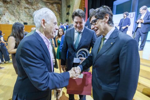 El president Salvador Illa saludant Antoni Coll en presència de Santiago Batchilleria