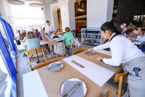 Una camarera prepara una mesa en el restaurante El Pòsit de Cambrils.