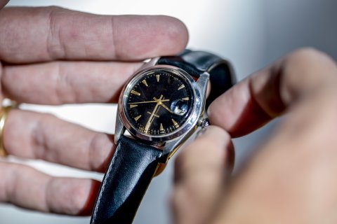 Un hombre cambiando la hora en su reloj