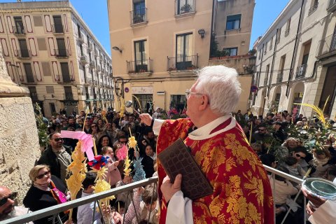 El prior de la Prioral de Sant Pere, mossèn Joaquim Fortuny, beneeix palmes i palmons durant la celebració del Diumenge de Rams a Reus.