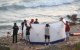 Gente que ha ayudado a salvar a los ahogados, servicios de emergencias y Mossos, en la playa Llarga.