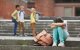 Imagen ficticia de tres adolescentes riéndose de una cuarta en el patio de una escuela.
