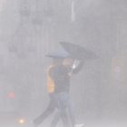 Personas se protegen de la lluvia.