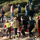 Efectivos de los cuerpos de emergencias y policiales retirando el cuerpo sin vida del hombre que se buscaba en el mar, en la Cala de la Roca Plana de Tarragona