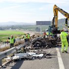 La carga de los tres camiones se ha esparcido por todo el asfalto.