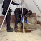 Los mossos inspeccionan la fosa séptica.
