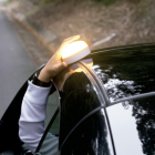 Una baliza V16 en el techo de un coche estacionado de forma irregular a causa de un percance.