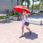 Una mujer se protege del sol con un paraguas en plena ola de calor.
