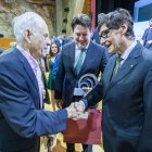 El president Salvador Illa saludant Antoni Coll en presència de Santiago Batchilleria