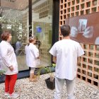 Infermers del CAP visionant l'exposició on es pot veure el procés.