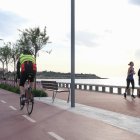 Personas haciendo deporte, en bicicleta y corriendo, en el paseo junto a la playa del Miracle de Tarragona._