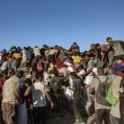 Palestinos suben a camiones de ayuda para conseguir alimentos cerca de un punto de distribución de alimentos