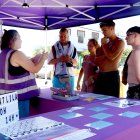 Una treballadora atén un grup de joves al punt lila mòbil a Creixell.