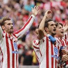 Los jugadores del Atlético de Madrid Antoine Griezmann, Koke y Giuliano saludan al público tras su victoria 5-2 en el partido ante el Real Madrid, este sábado