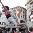 Una de les components de la Vella de Valls saltant als braços després de descarregar un castell.