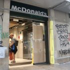 Cartones para cubrir los cristales rotos de la puerta de un establecimiento de comida rápida en La Rambla, Barcelona