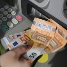 Una persona saca dinero de un cajero automático.