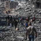 Palestinos caminan por una calle entre los escombros de los edificios destruidos durante un alto el fuego entre Israel y Hamás