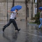 Una persona se protege de la intensa lluvia este viernes en Alicante, donde ha golpeado la dana Alice.