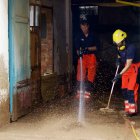 Bombers evacuant aigua en els baixos d'una casa