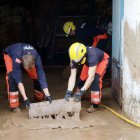 Bomberos achicando agua de una casa.