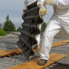 Un operario retira restos de amianto de un tejado.