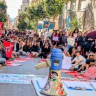 Decenas de estudiantes sentados delante de la sede de Ensenyament.