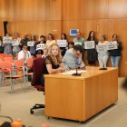 Trabajadores protestando con carteles en el último pleno.