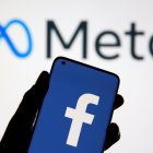 El logo de Meta y un móvil con el logo de Facebook.